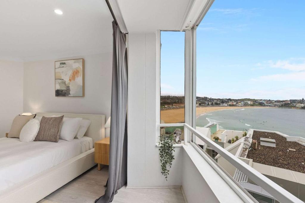 a living room with a couch and a view of the ocean at Iconic Bondi Beach Views in Sydney