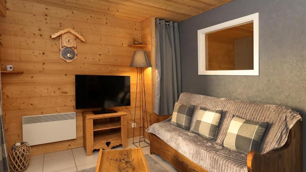 un salon avec un canapé et une télévision à écran plat dans l'établissement La Belle Vue Gérardmer, à Gérardmer