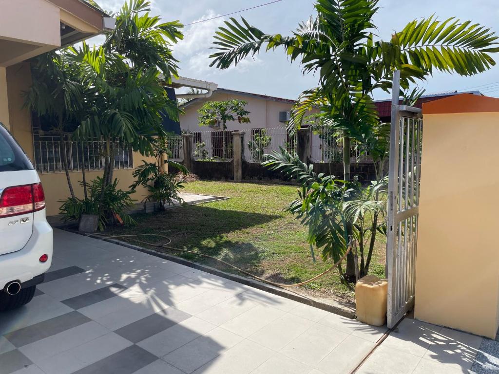 a white car parked in front of a house with trees at Bintang Haven in Tawau