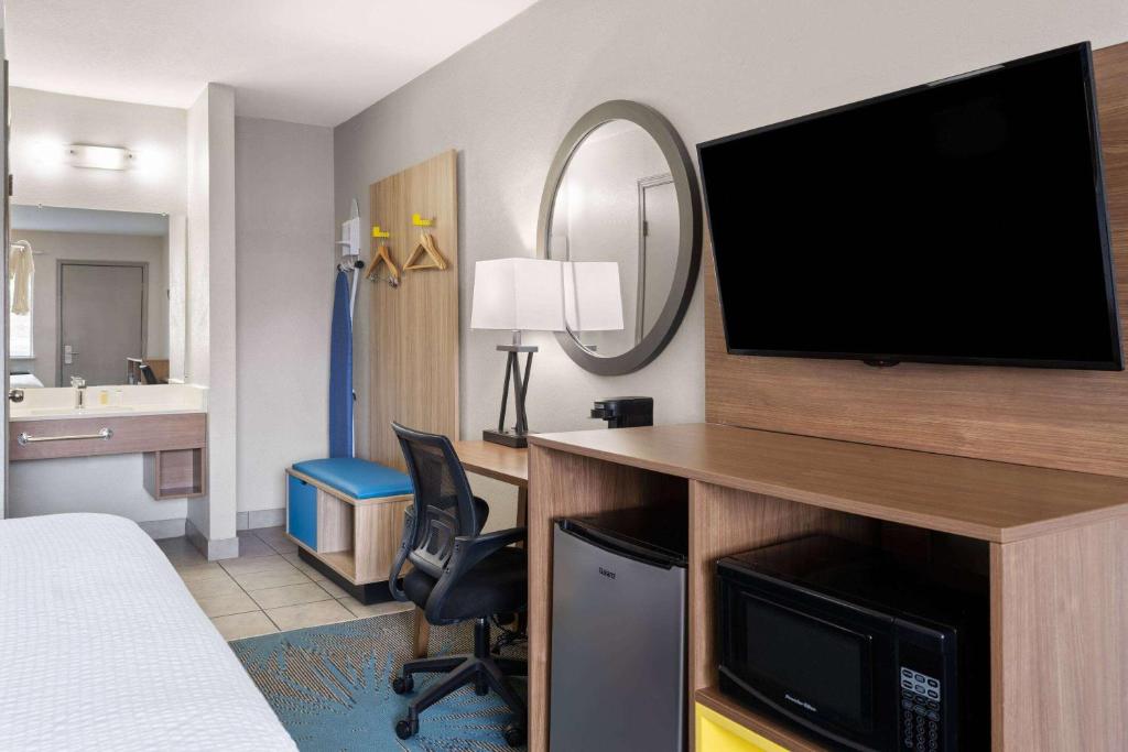 a hotel room with a bed and a flat screen tv at Days Inn by Wyndham Ardmore in Ardmore