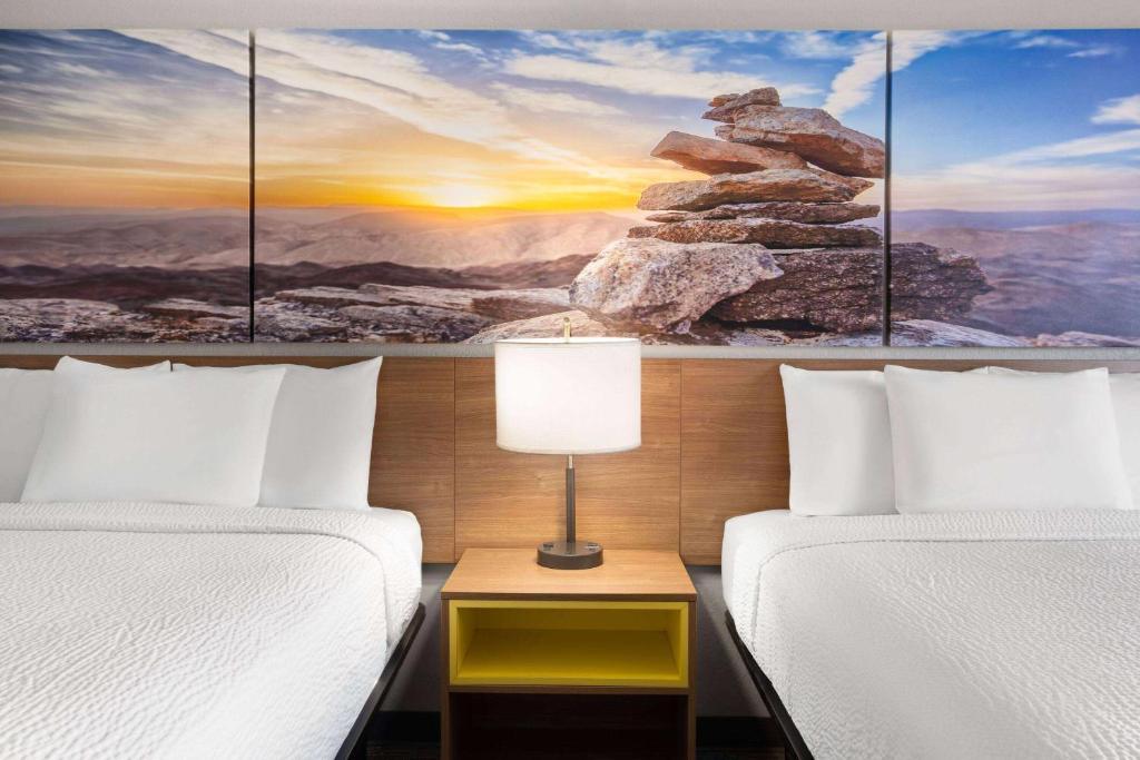 a hotel room with two beds and a painting at Days Inn by Wyndham Ardmore in Ardmore