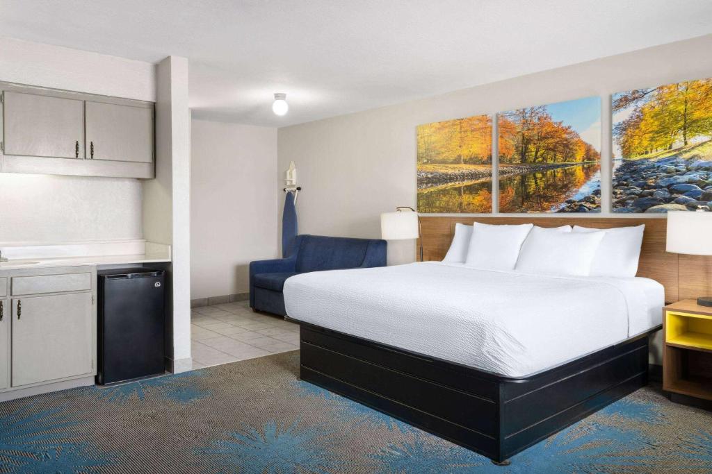 a hotel room with a bed and a kitchen at Days Inn by Wyndham Ardmore in Ardmore