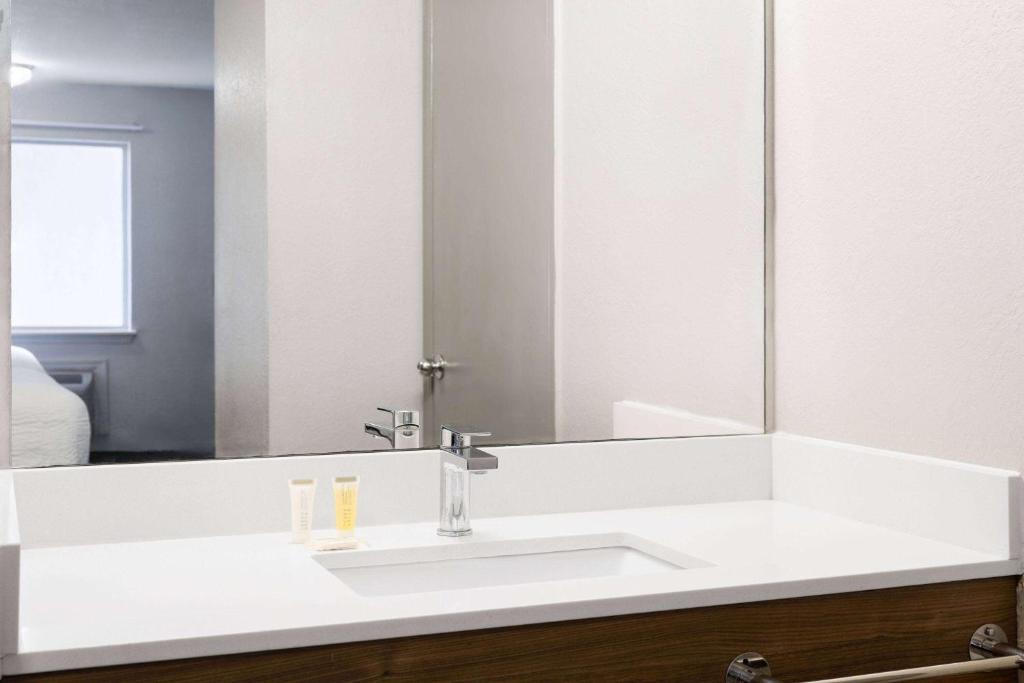 a bathroom with a white sink and a mirror at Days Inn by Wyndham Ardmore in Ardmore