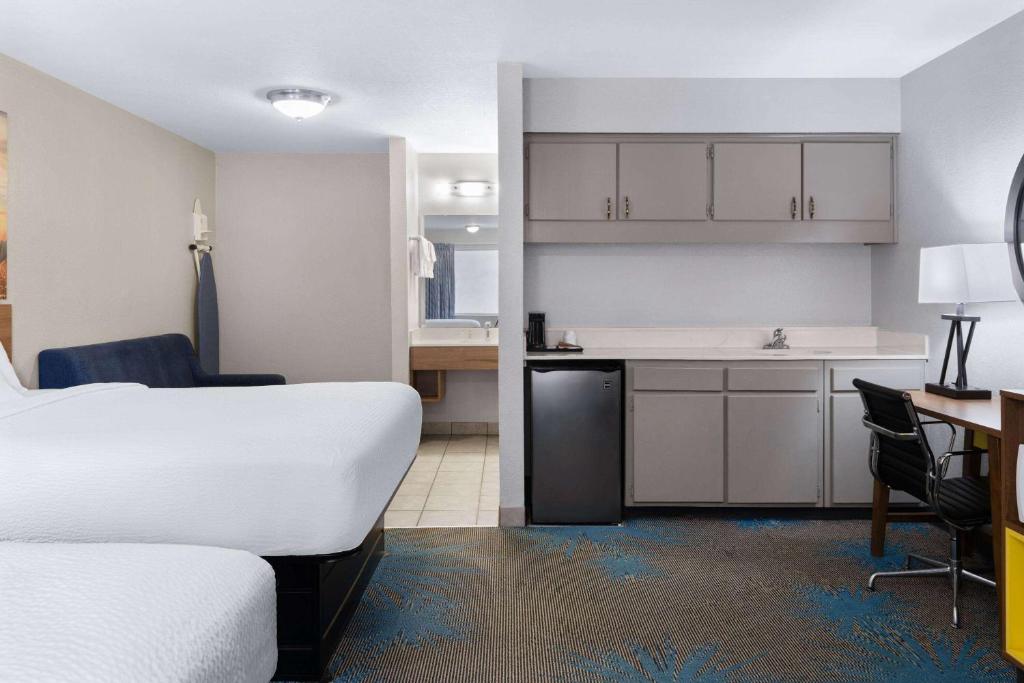 a hotel room with a bed and a kitchen at Days Inn by Wyndham Ardmore in Ardmore