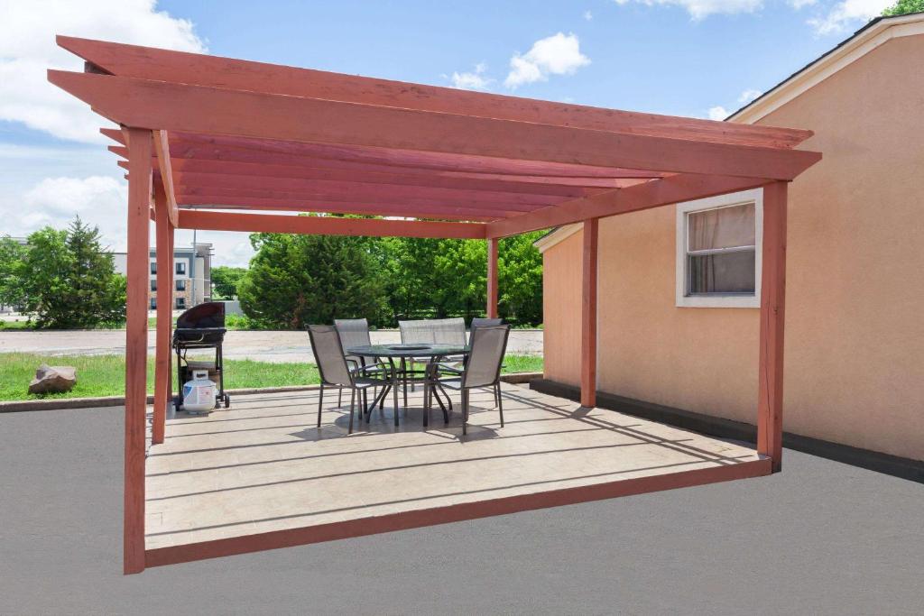 a wooden deck with a table and chairs on it at Days Inn by Wyndham Ardmore in Ardmore