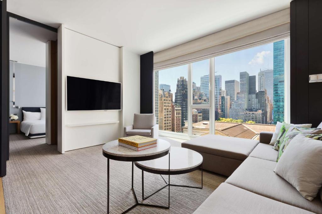 a living room with a couch and a large window at Andaz 5th Avenue, By Hyatt in New York