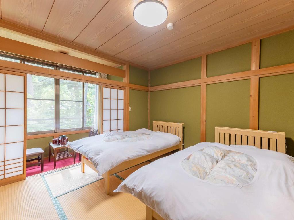 Postel nebo postele na pokoji v ubytování 檜湯の宿　松伯