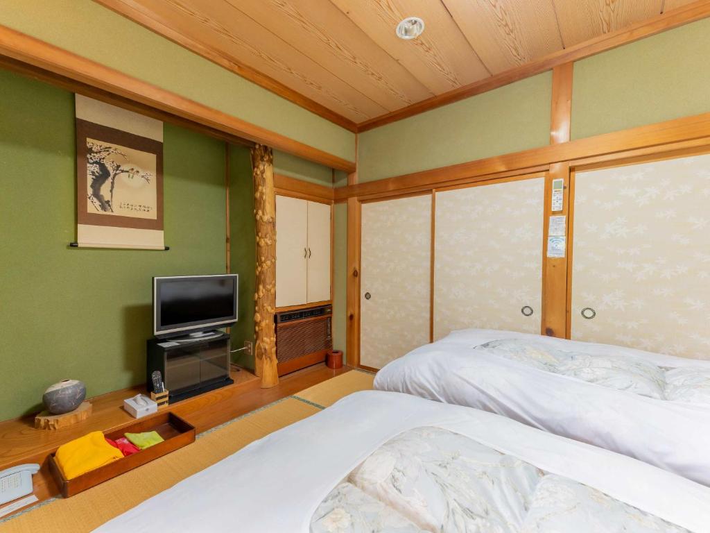 Postel nebo postele na pokoji v ubytování 檜湯の宿　松伯