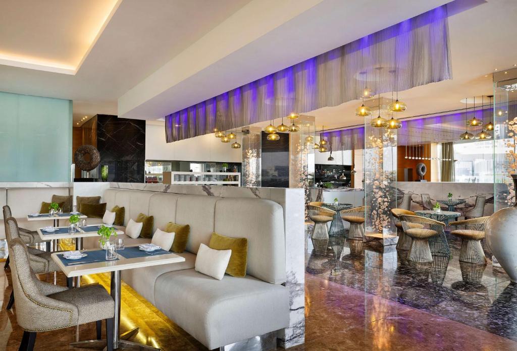 a restaurant with a bar with tables and chairs at Conrad Abu Dhabi Etihad Towers in Abu Dhabi