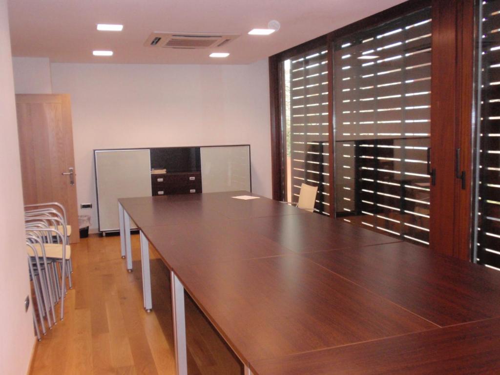 una sala de conferencias con una gran mesa de madera y sillas en Posada Miranda, en Miranda del Castañar