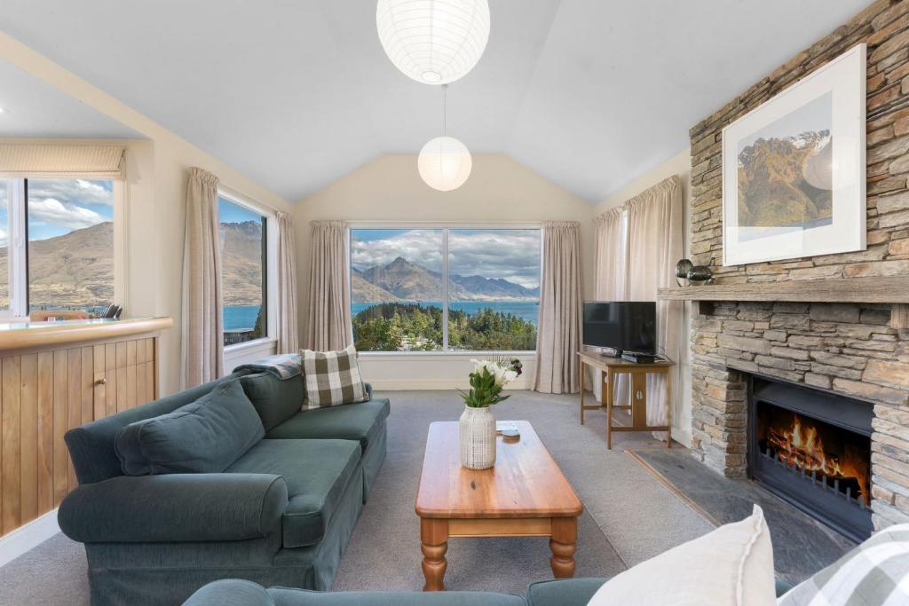 a living room with a couch and a fireplace at Queenstown Peaks in Queenstown