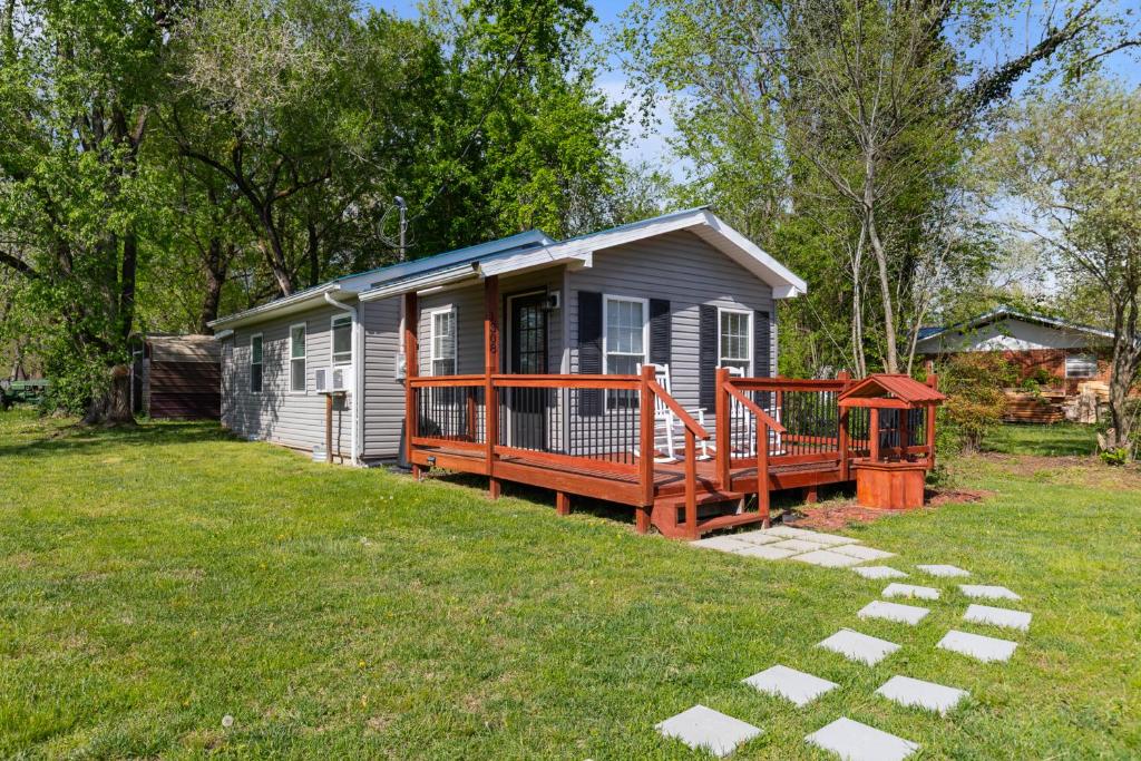 a tiny house with a large deck in a yard at Little Bit Of Country in Sevierville
