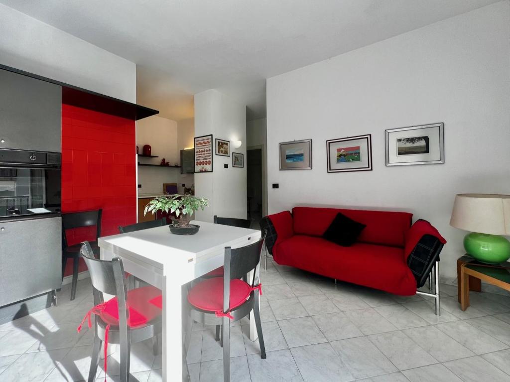 a living room with a red couch and a table at Villa Rocca - appartamento 3 in Borgio Verezzi
