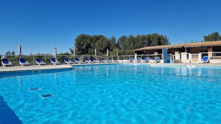 - une grande piscine d'eau bleue avec des chaises dans l'établissement Les Hauts de Balaruc studio ou T2, rénovés , climatisés, vue panoramique, parking, à Balaruc-les-Bains