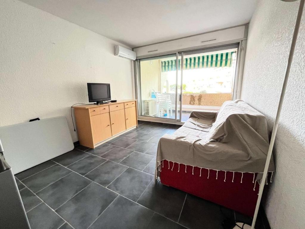 Cette chambre comprend un lit et une télévision. dans l'établissement Résidence Quai Aux Fleurs - Studio 4 couchages avec piscine MAE-5391, au Grau-du-Roi