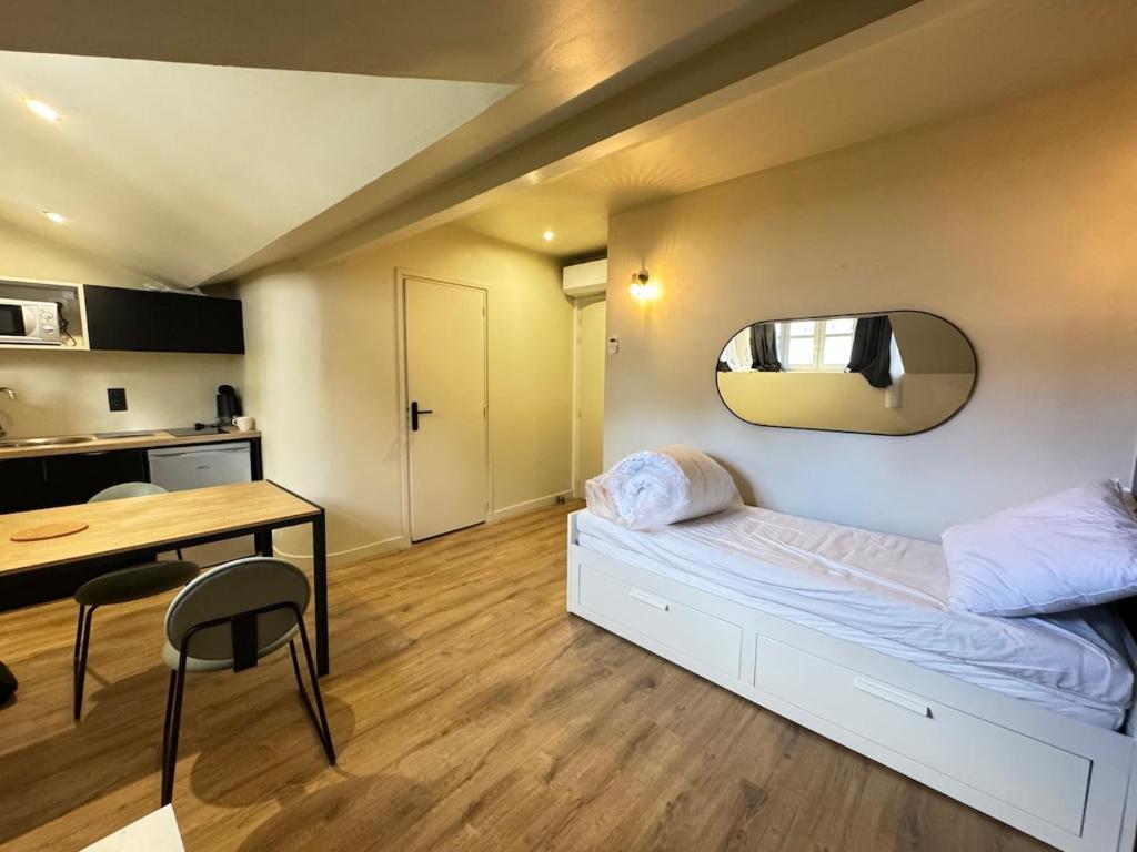 une chambre avec un lit, une table et un miroir dans l'établissement Studio cosy avec salle de sport, à Saint-Étienne