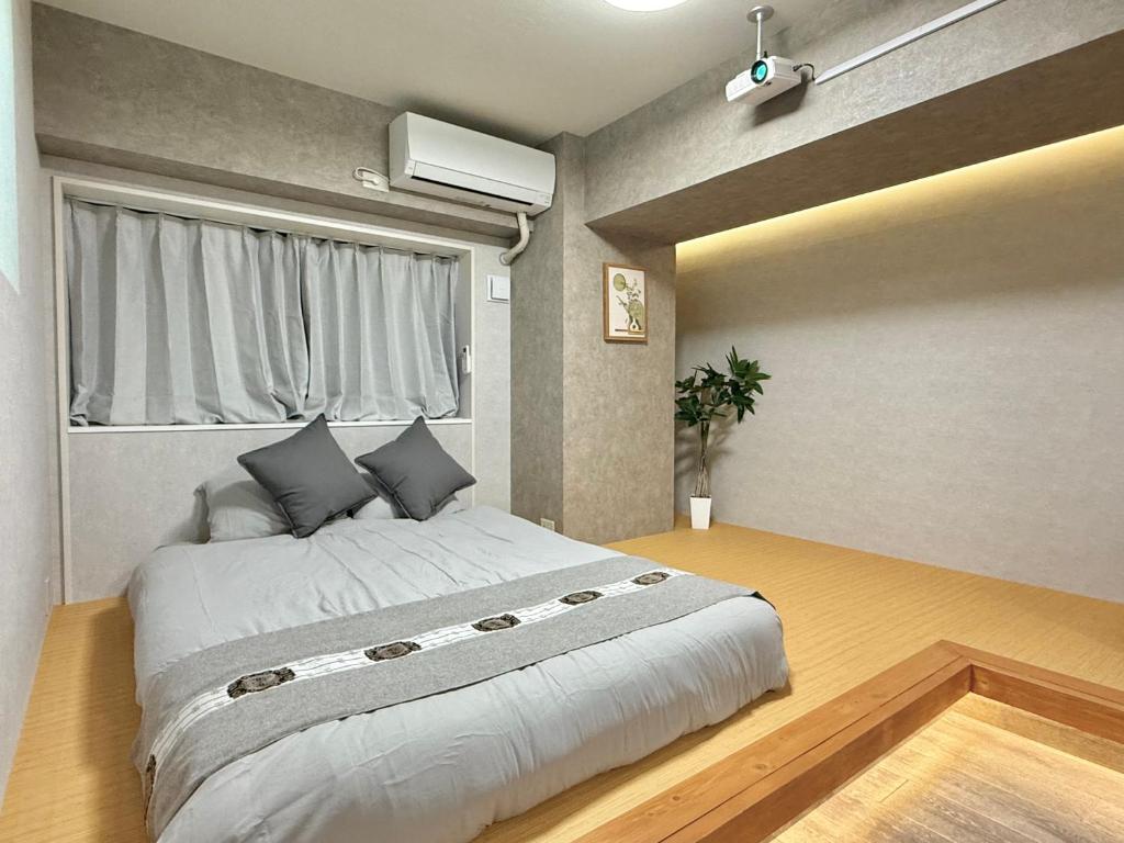 a bedroom with a large bed and a window at 桜南大塚ハウスii in Tokyo