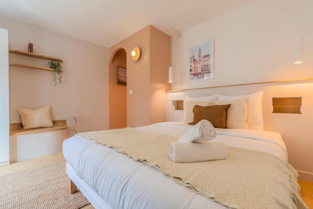 - une chambre avec un grand lit blanc et une serviette dans l'établissement Petit studio proche écoles & commodités, à Lille
