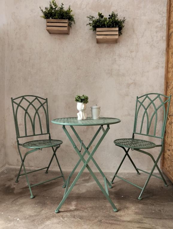 two chairs and a glass table and a table and chairs at Maison Chèrie in Parabita