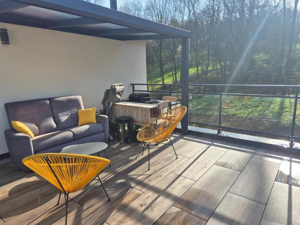 d'un salon avec un canapé et des chaises sur un balcon. dans l'établissement Appartement 1 chambre et terrasse, à Vienne