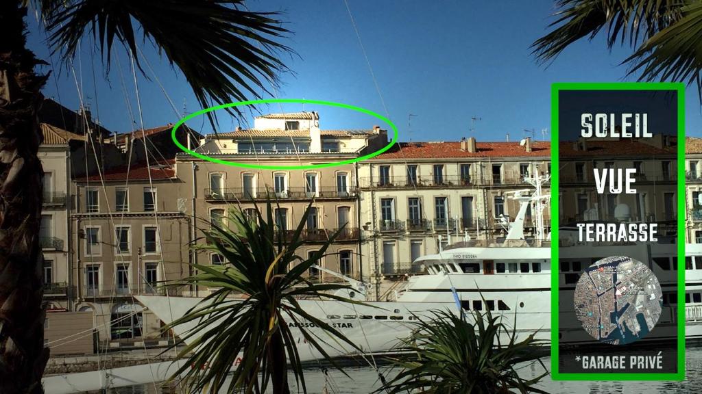 un bâtiment avec un cercle vert devant un bateau dans l'établissement Entre Ciel et Mer, à Sète