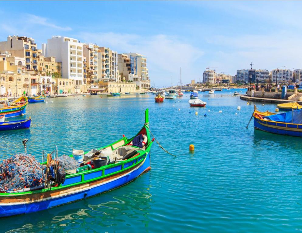 a group of boats in a body of water with buildings at La Bella Guesthouse in St. Julianʼs