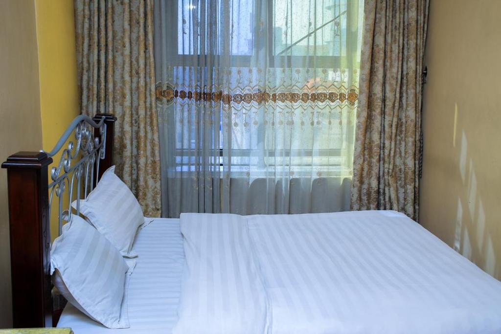 Postel nebo postele na pokoji v ubytování EXCELLENT HOTEL KAMPAlA