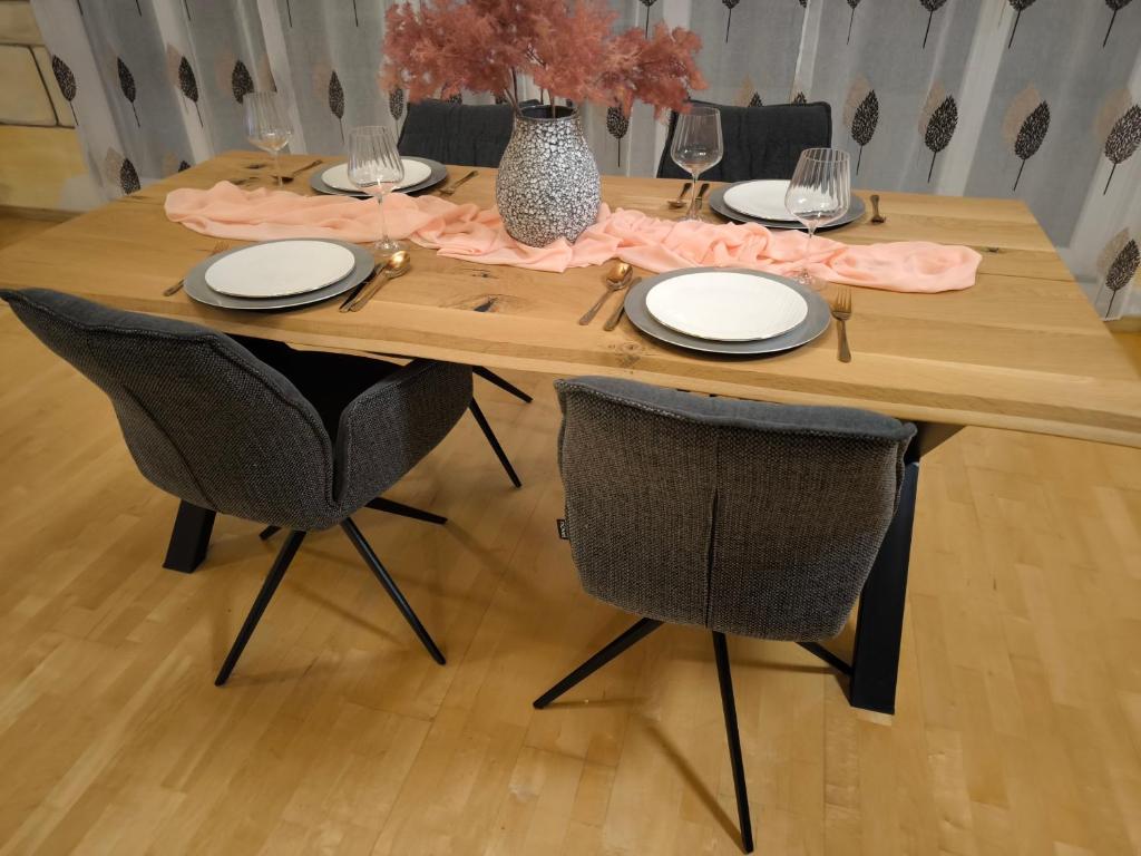 a wooden table with two chairs and a table with plates at Diane Appartement in Scheer