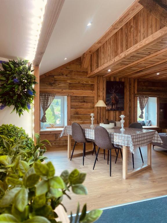a dining room with a table and chairs at Gîtes les cocons des guédons Le Douglas in Le Ménil