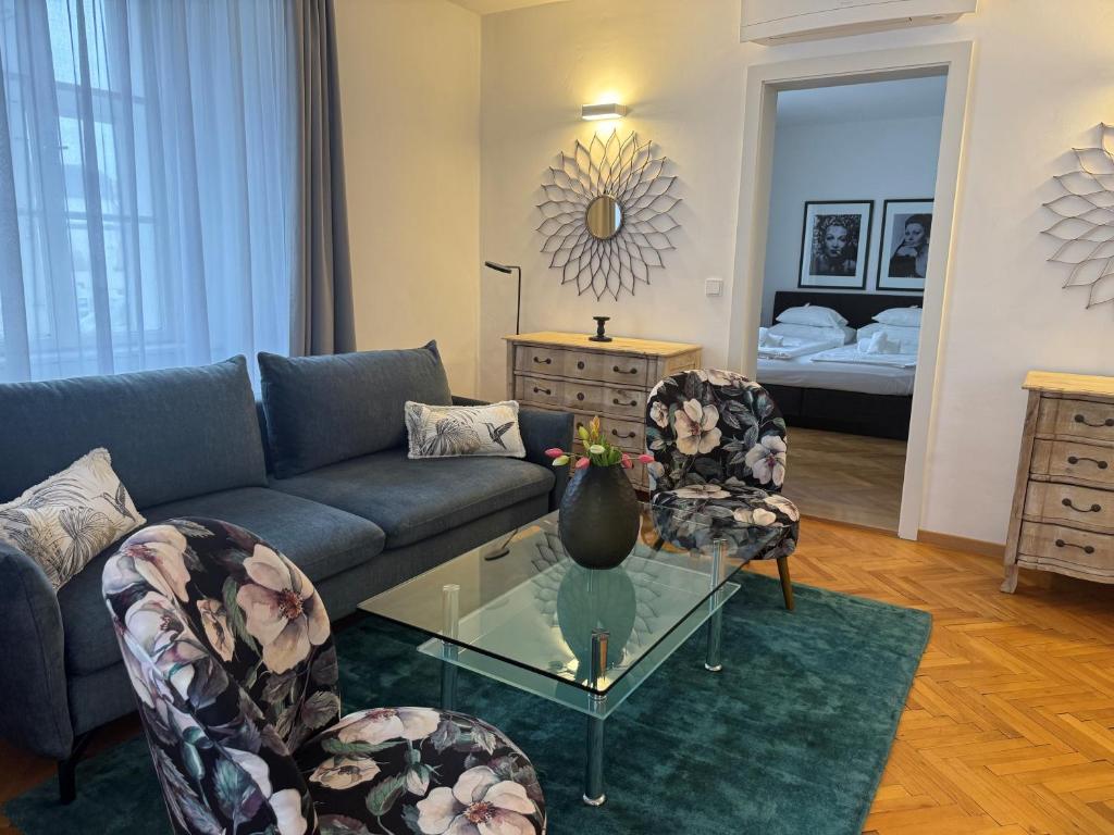 a living room with a couch and a glass table at Smile Apartments zum Goldenen Hirschen in Krems an der Donau