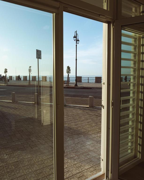 an open glass door with a view of the beach at A'mare in Giovinazzo