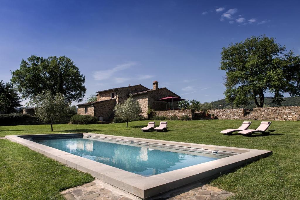 a swimming pool with two lounge chairs and a house at Il Prado Private Pool, Nature, Greve In Chianti in Greve in Chianti