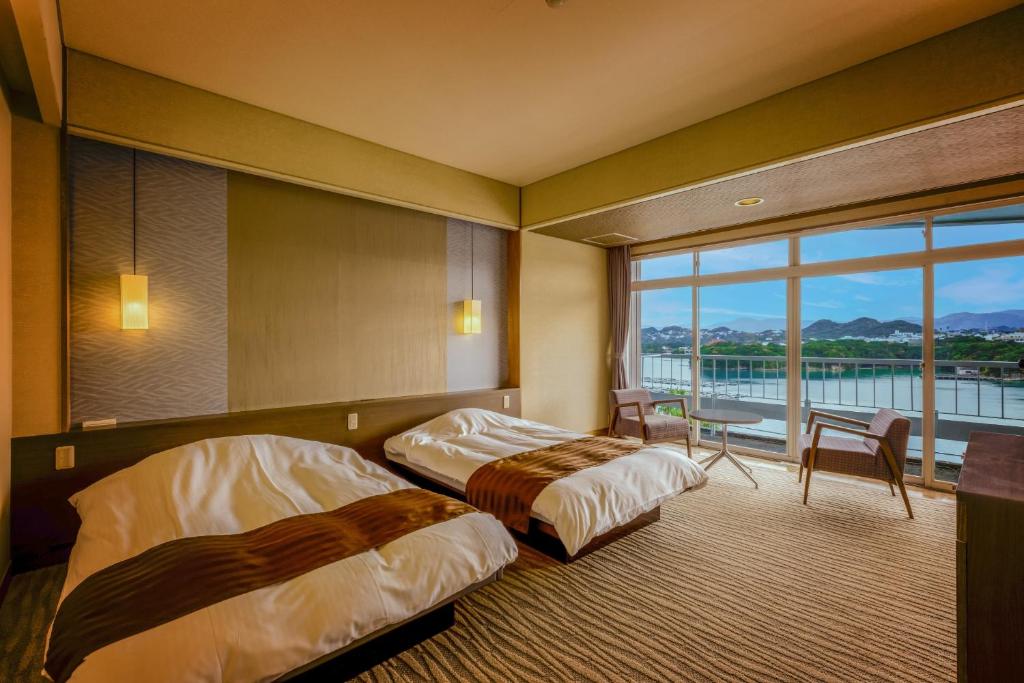 Postel nebo postele na pokoji v ubytování Ooedo Onsen Monogatari Premium Shirahama Saichoraku