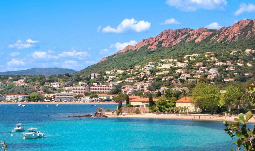 - une vue sur une plage avec des bateaux dans l'eau dans l'établissement Très belle T2, vue mer ,Le Tout a Pied, à Saint-Raphaël