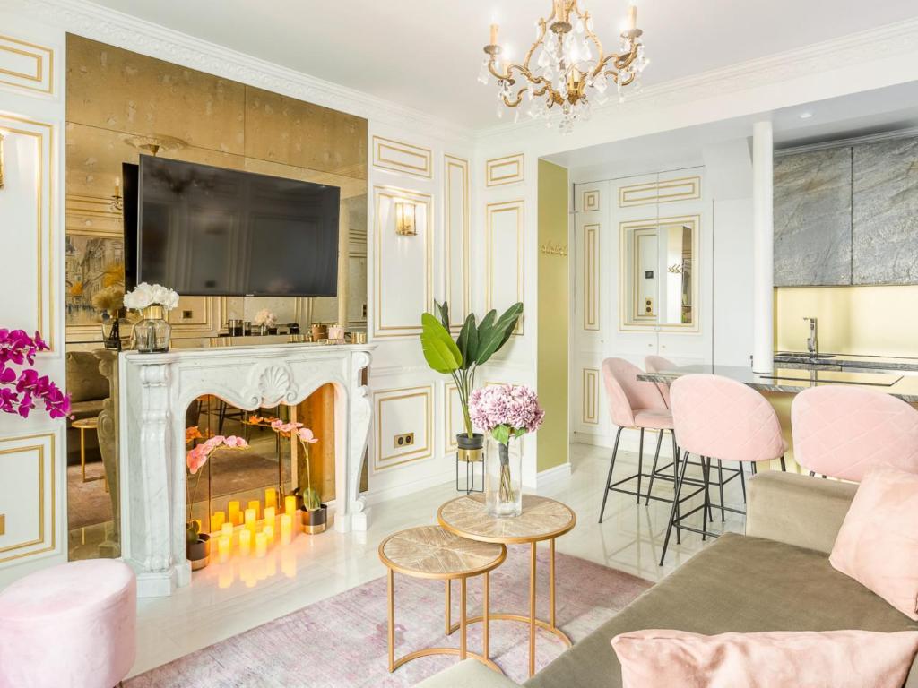- un salon avec une cheminée et des chaises roses dans l'établissement Merveil - Luxury Suite - Tour Eiffel - Bourdonnais, à Paris
