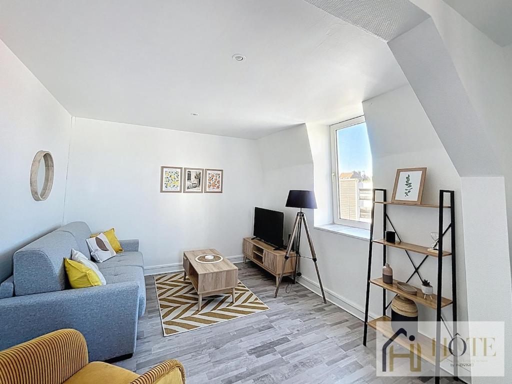 un salon avec un canapé bleu et une télévision dans l'établissement L'Appartement du Centre 1CH, à Dunkerque