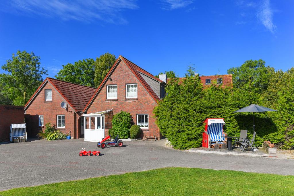 ein Haus mit Spielzeugautos in der Einfahrt geparkt in der Unterkunft Ferienwohnungen und Ferienhaus Polmann in Nordwerdum in Werdum