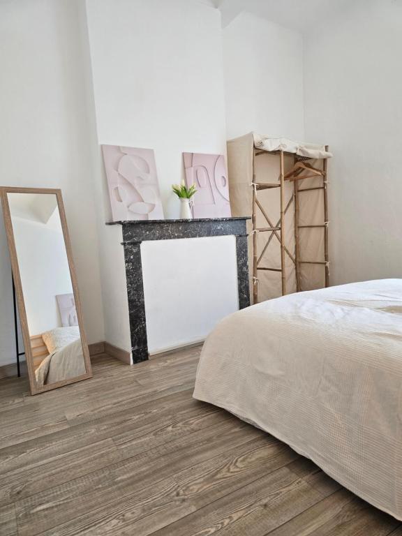 une chambre avec un lit et un miroir dans l'établissement Moderne et lumineux provençal, à Belgentier