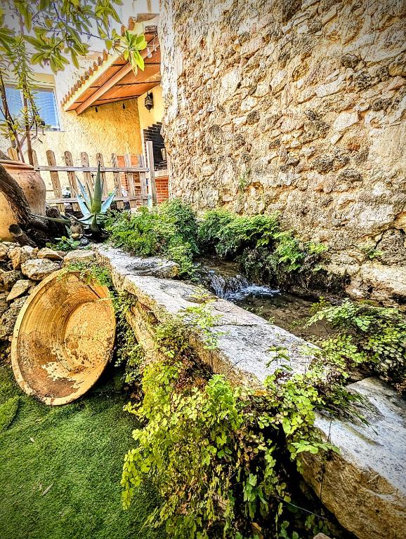 a stone wall with a creek in front of a house at Casa Fina in Anna