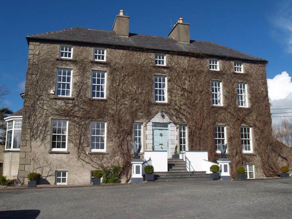 a large brick building with a blue door at Castlemorris House in Tralee
