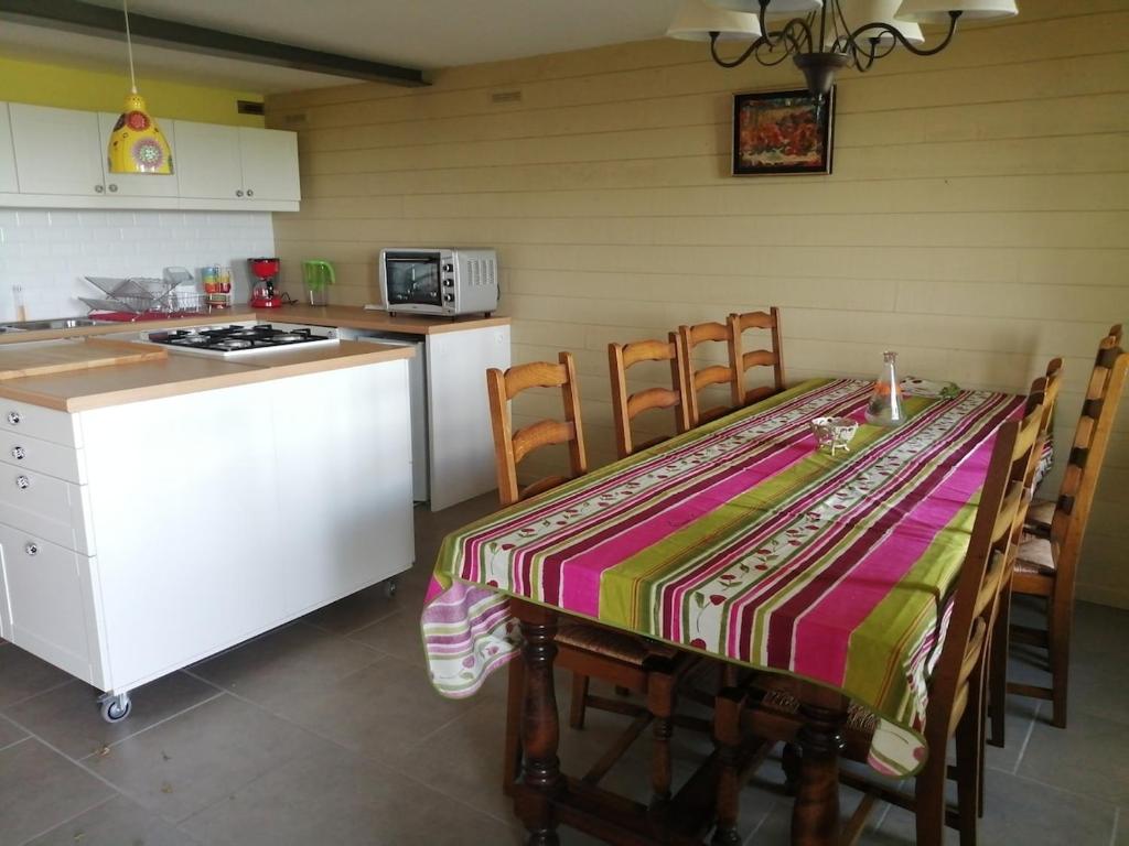 a kitchen with a table with a colorful table cloth on it at Charmante petite maison proche de Meymac in Meymac