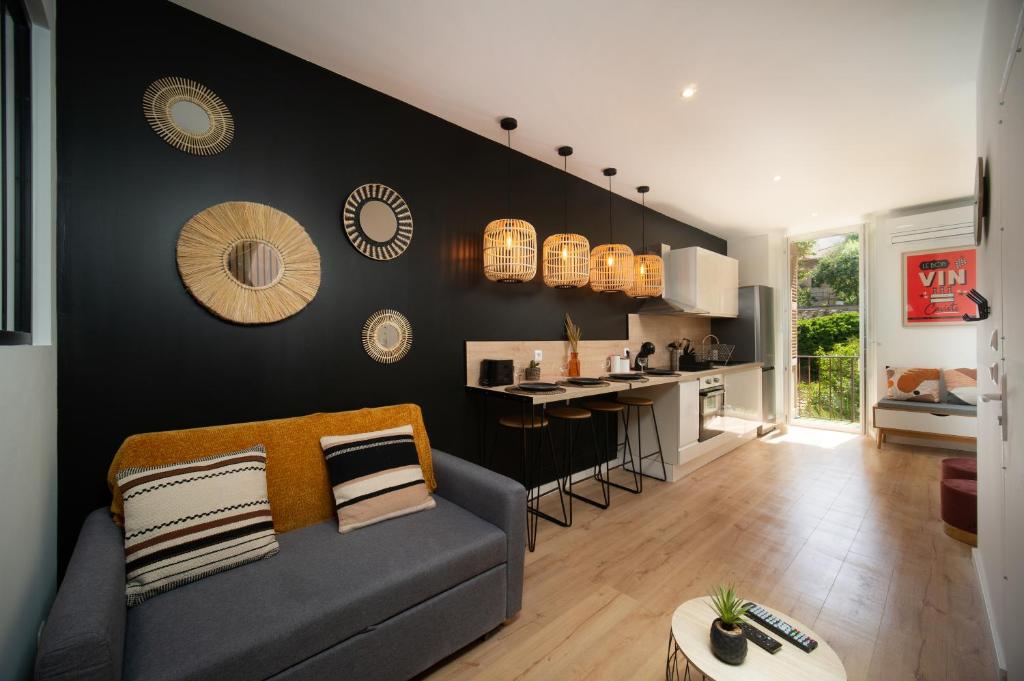 un salon avec un canapé et une cuisine dans l'établissement Appartement climatisé 2 chambres avec parking à 10min à pieds de la Gare St Charles, à Marseille