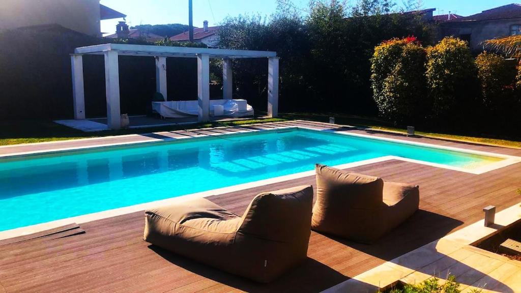 una piscina con due sedie su una terrazza di legno di Exclusive Villa with Private Swimming Pool a Nicola