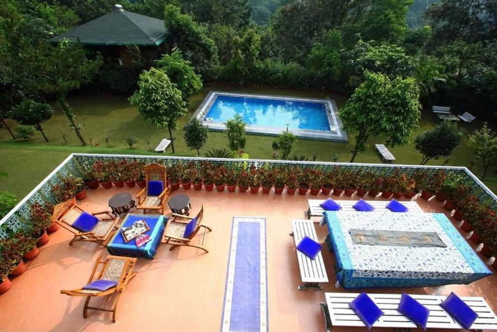 an aerial view of a swimming pool with chairs and a swimming pool at Shaheen Bagh - A Luxury Boutique Resort & Spa in Rājpur