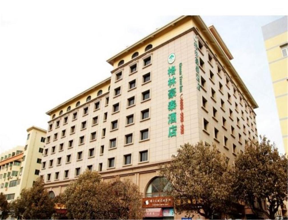 un edificio con un cartel en el costado en GreenTree Inn Shandong Qingdao Wuyishan Road Jiashike Shopping center Business Hotel, en Huangdao