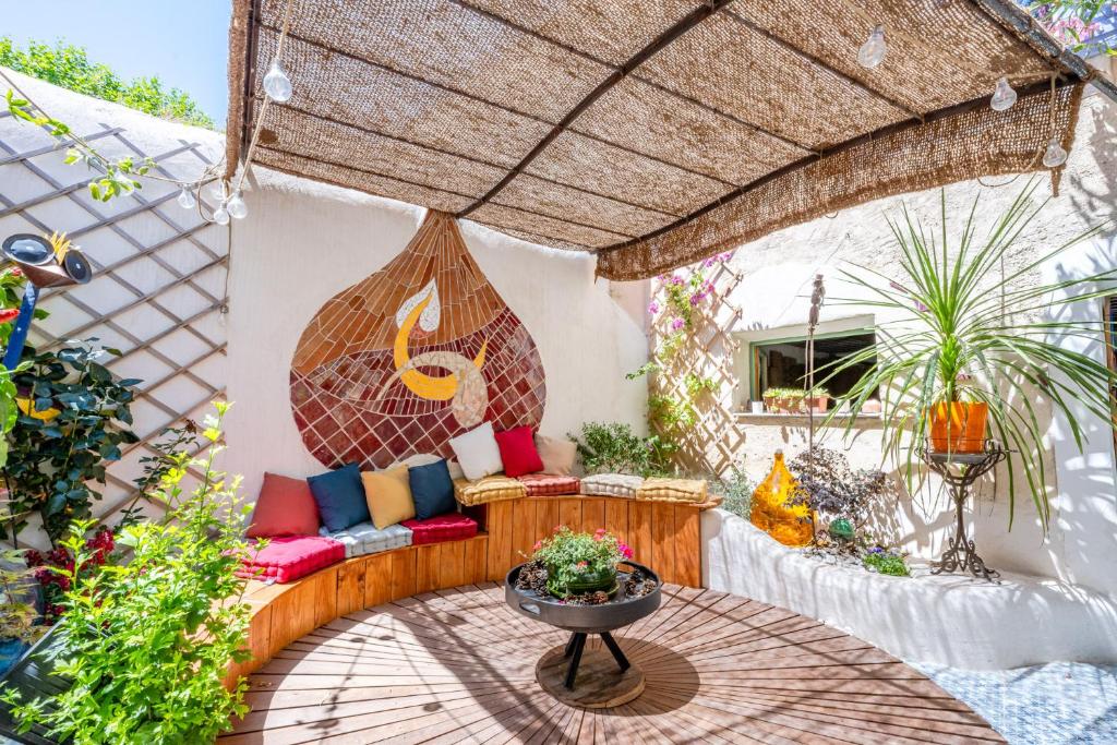 une terrasse avec un canapé et une table dans l'établissement Aux Heures Bleues, à LʼIsle-sur-la-Sorgue