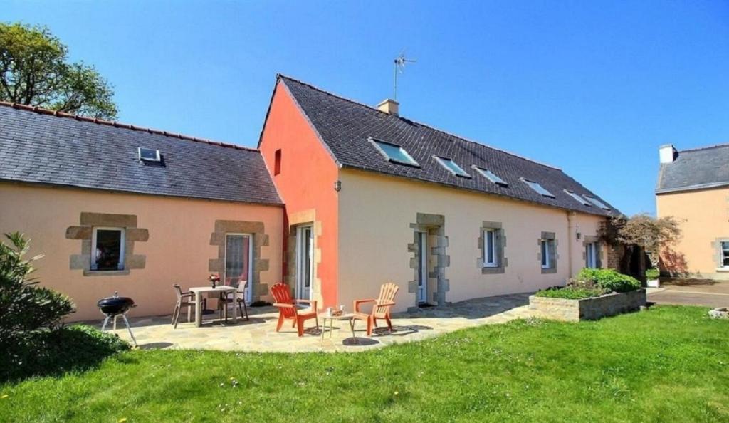 a house with a table and chairs in a yard at Plain pied en rez de jardin à la campagne et proche de l'océan in Mahalon