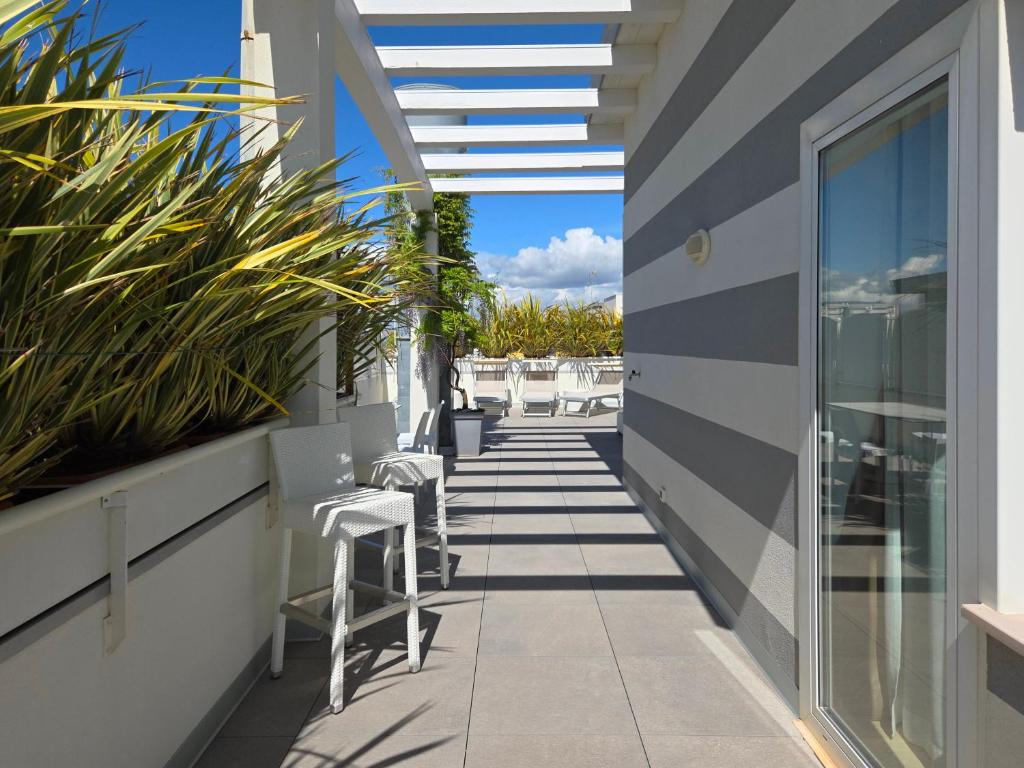 a balcony with chairs and tables on a building at Hotel Lux in Caorle