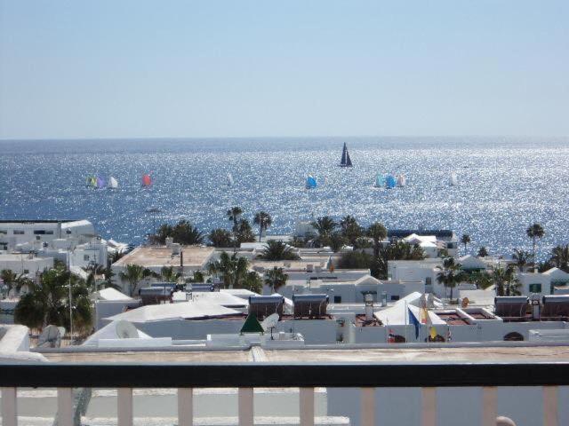 widok na plażę z łodzią w wodzie w obiekcie Casa Josephine Lanzarote, spectacular sea views & FREE WiFi w Puerto del Carmen