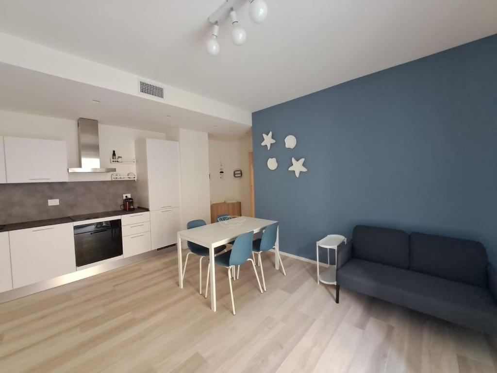 a living room with a couch and a table and chairs at Design a PSG con aria condizionata in Porto San Giorgio